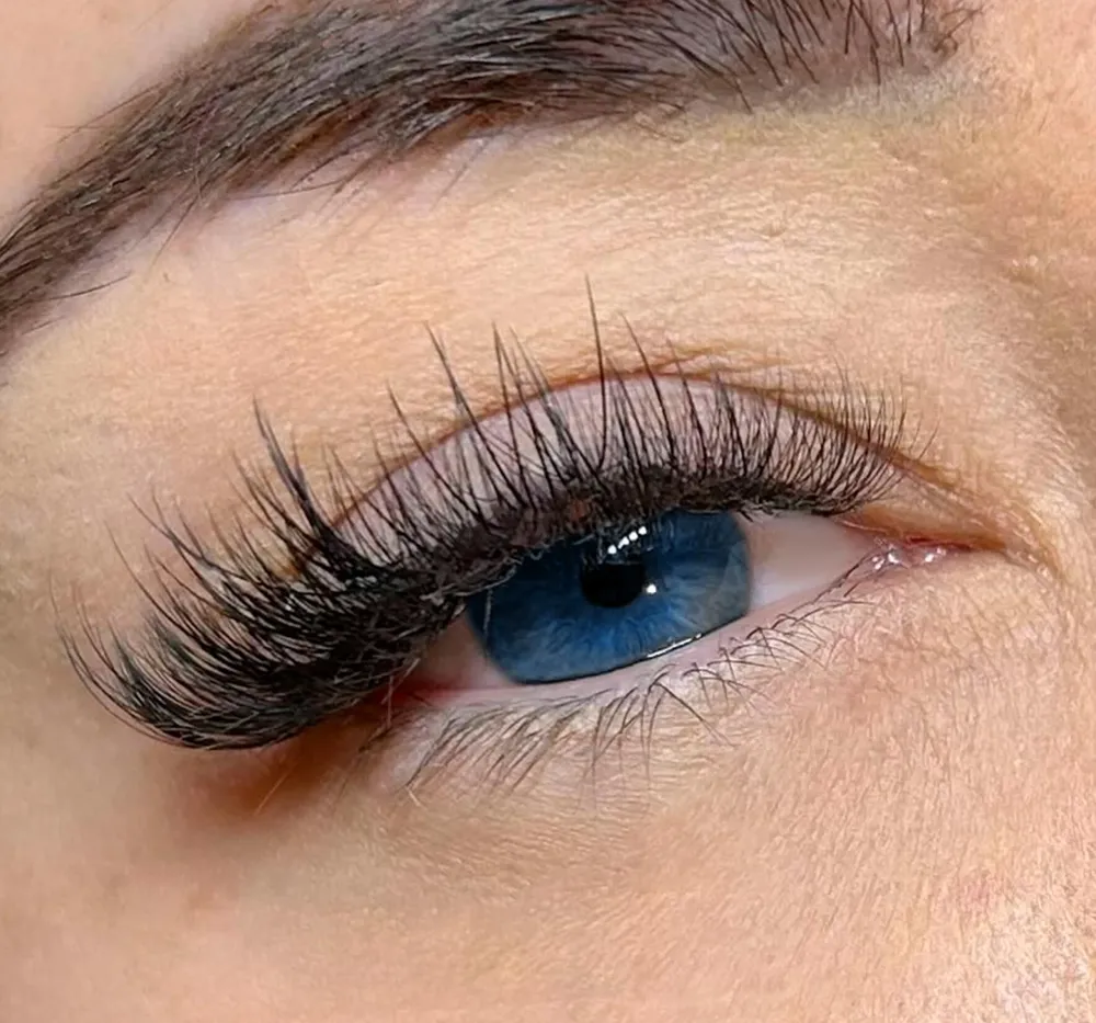 Hybrid lash extensions on blue eyes, Caucasian client close-up